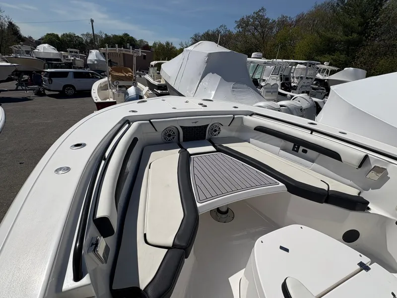 Slide: The Image of 2023 Tidewater 272 LXF boat interior with seating and table, docked among other boats. - 10