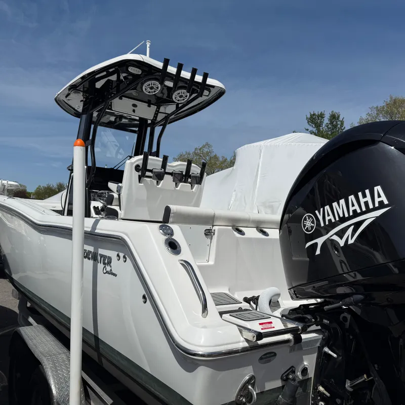 Slide: The Image of 2023 Tidewater 272 LXF boat with Yamaha engine, parked outdoors under clear sky. - 2
