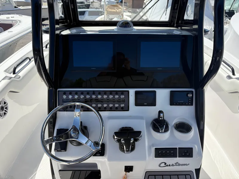 Slide: The Image of 2023 Tidewater 272 LXF boat dashboard with dual screens and steering wheel. - 3