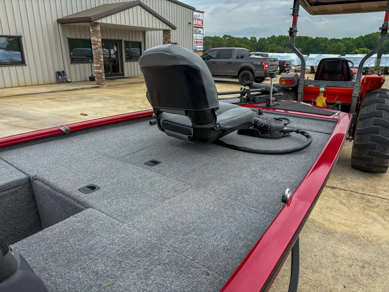 Slide: The Image of 2024 Tracker Pro 170 boat with red trim and seating, parked outdoors. - 11