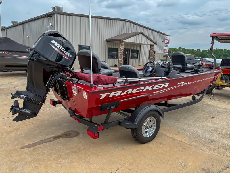 Slide: The Image of 2024 Tracker Pro 170 boat with Mercury engine on trailer, parked outside a building. - 6