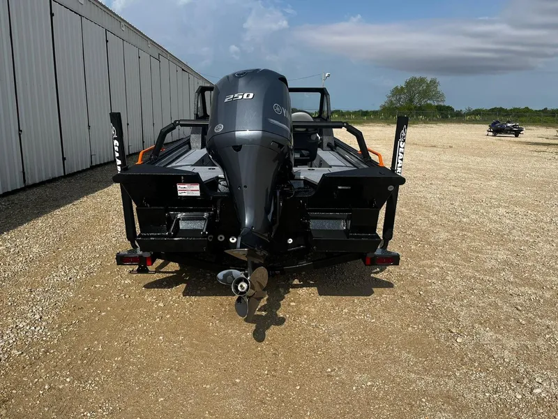 Slide: The Image of 2025 SeaArk ProCat 240 boat with powerful 250 engine, parked outdoors on gravel. - 6