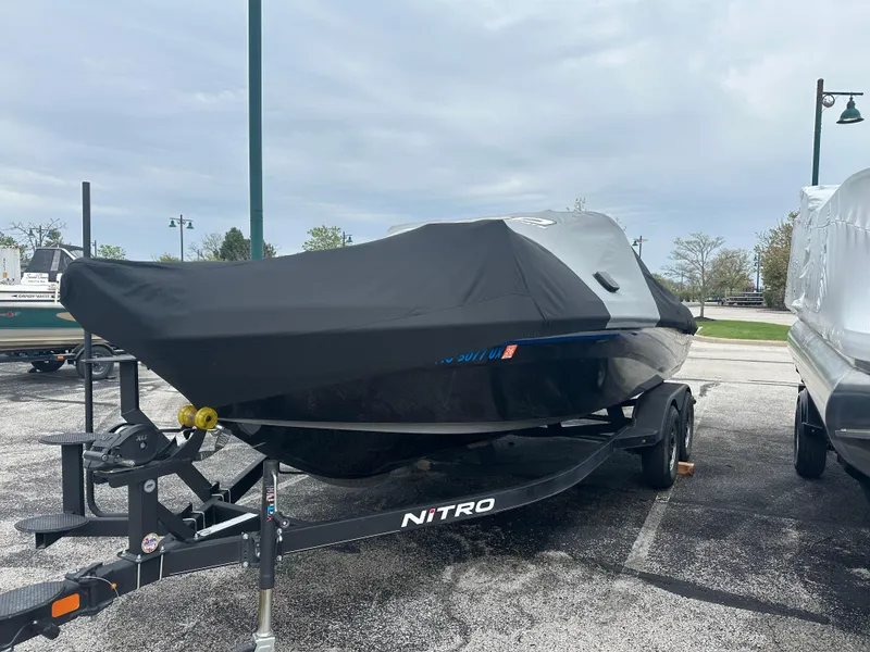 Slide: The Image of 2023 Nitro ZV19 Pro boat covered on trailer in parking lot. - 0
