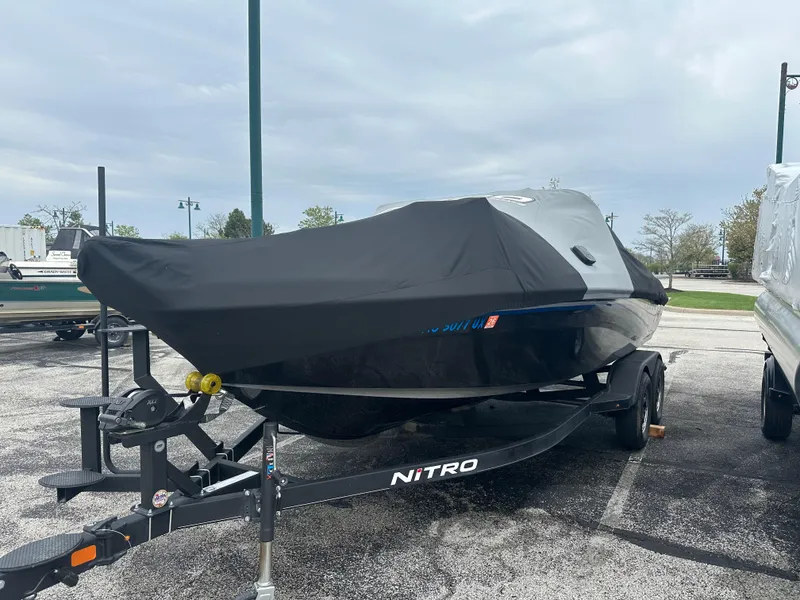 Slide: The Image of 2023 Nitro ZV19 Pro boat covered on a trailer in a parking lot. - 1