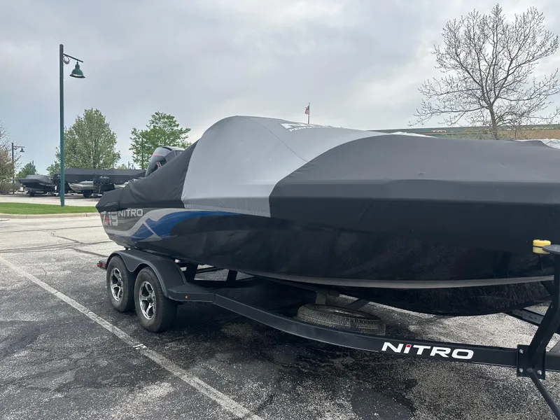 Slide: The Image of 2023 Nitro ZV19 Pro boat covered on a trailer in a parking lot. - 2