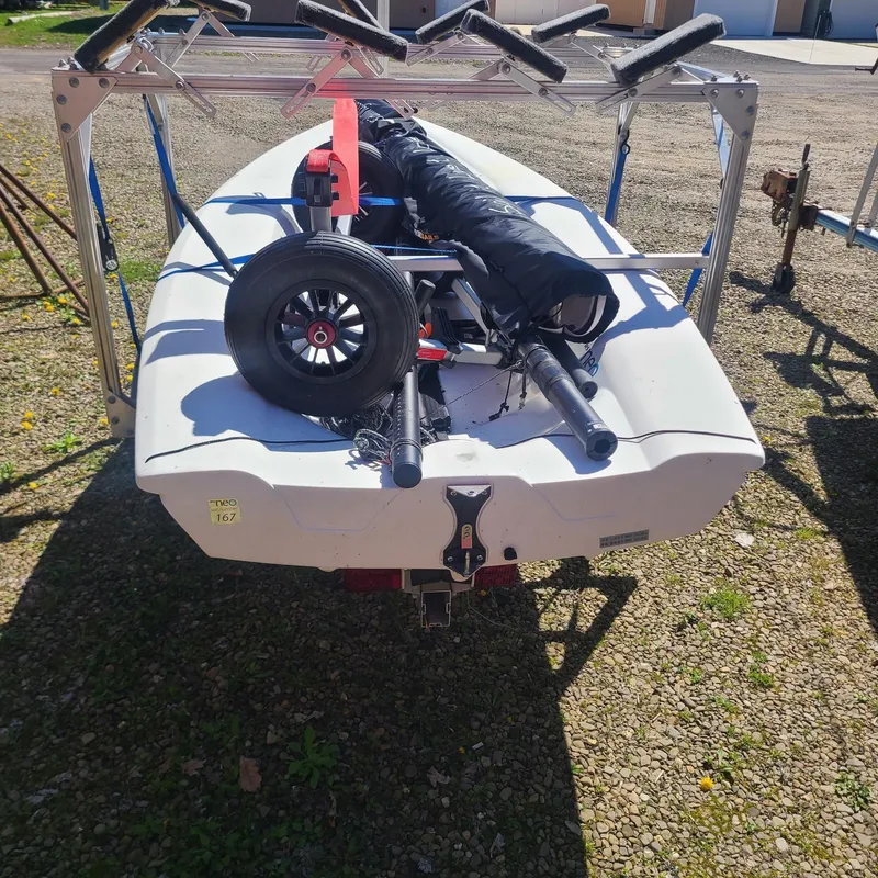 Slide: The Image of 2017 RS Neo sailboat on trailer with equipment, parked on gravel. - 2