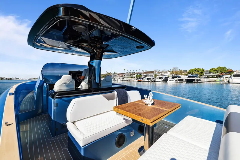 Slide: The Image of 2023 Solaris Power 40 Open yacht with elegant seating and table, docked by a marina. - 13
