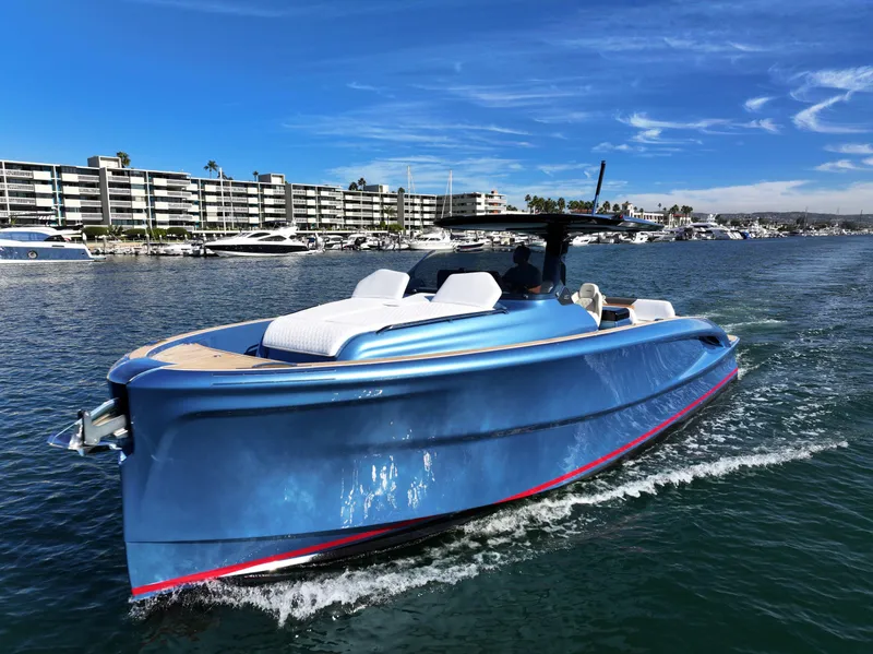 Slide: The Image of 2023 Solaris Power 40 Open yacht cruising in a marina with modern buildings in the background. - 2