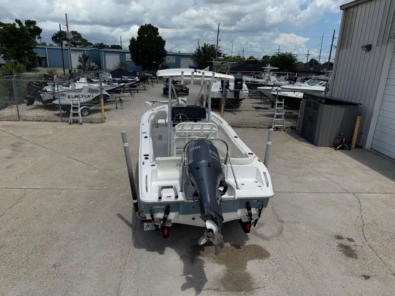 Slide: The Image of 2021 Sea Hunt Ultra 219 boat with outboard motor in a marina setting. - 13