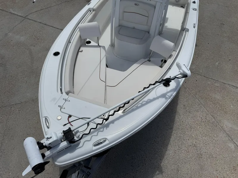 Slide: The Image of 2021 Sea Hunt Ultra 219 boat with trolling motor, white interior, and seating. - 18