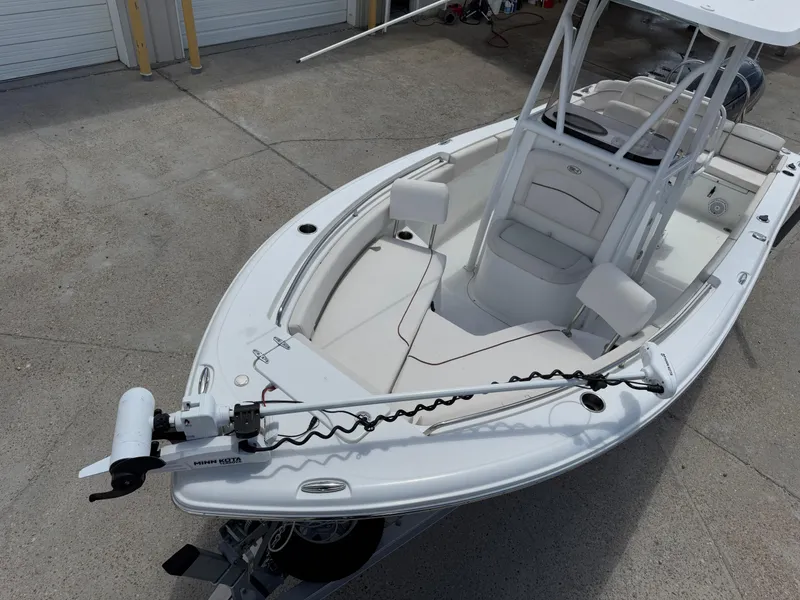 Slide: The Image of 2021 Sea Hunt Ultra 219 boat with Minn Kota trolling motor, parked on concrete. - 20