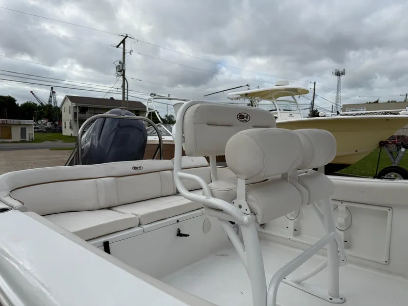 Slide: The Image of 2021 Sea Hunt Ultra 219 boat interior with white seating and overcast sky. - 25