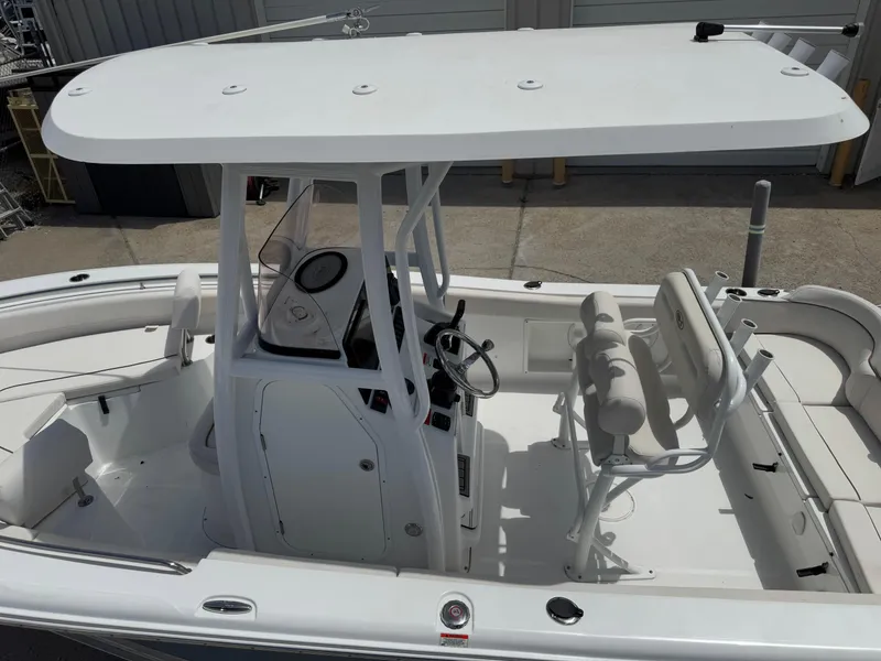 Slide: The Image of 2021 Sea Hunt Ultra 219 boat with T-top and dual seating, docked in a marina. - 26