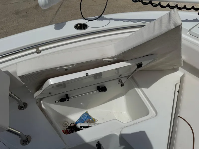 Slide: The Image of Open storage compartment on 2021 Sea Hunt Ultra 219 boat, showing interior and contents. - 44