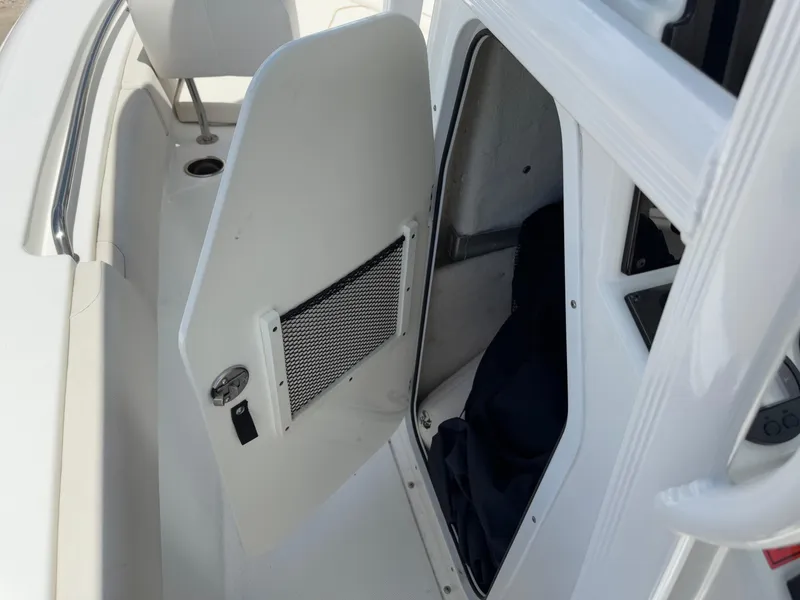 Slide: The Image of 2021 Sea Hunt Ultra 219 boat interior storage compartment with open door. - 46
