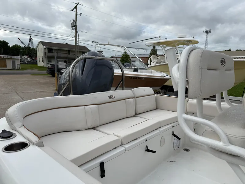 Slide: The Image of 2021 Sea Hunt Ultra 219 boat with white seating, docked outdoors under cloudy skies. - 6