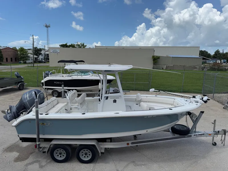 Slide: The Image of 2021 Sea Hunt Ultra 219 boat on trailer, parked outdoors under a cloudy sky. - 7