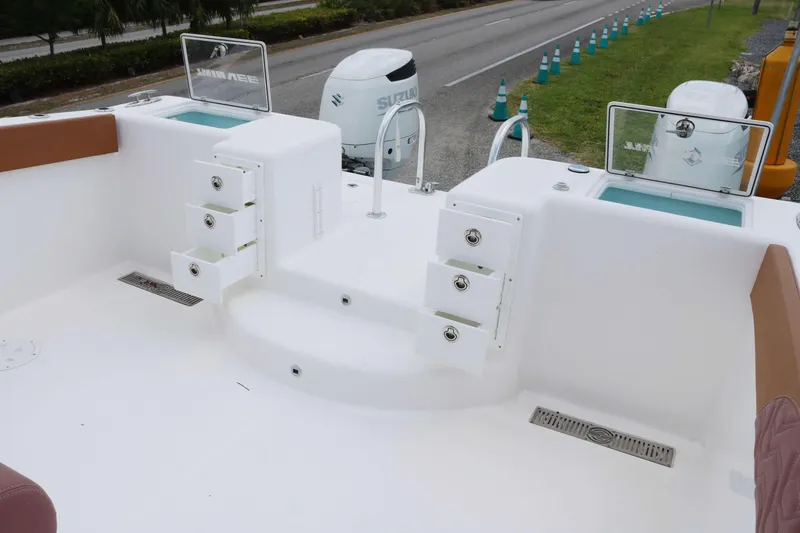 Slide: The Image of 2022 Twin Vee 340 GFX boat deck with storage compartments and dual Suzuki outboard engines. - 12