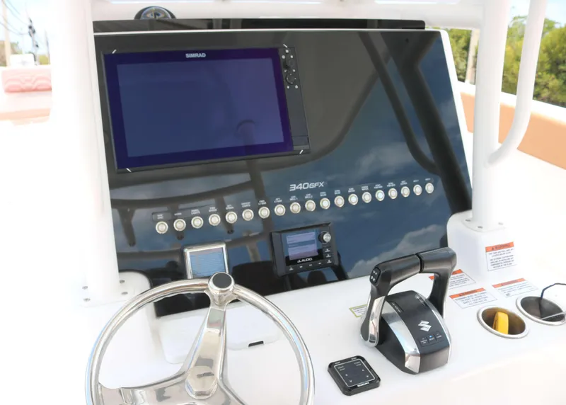 Slide: The Image of 2022 Twin Vee 340 GFX boat dashboard with steering wheel and control panel. - 6