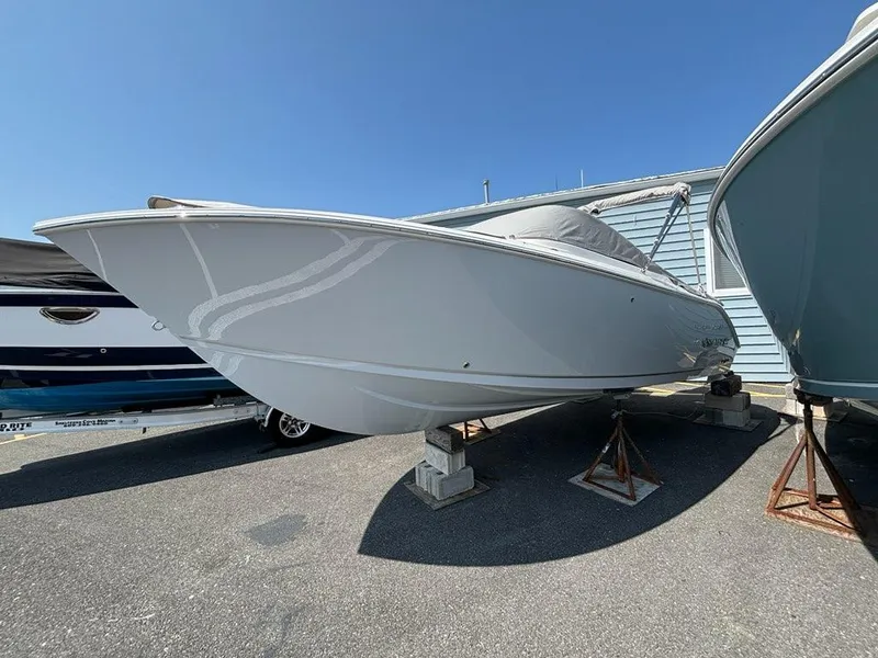 Slide: The Image of 2026 Sailfish 236 DC boat on stands, displayed outdoors under clear blue sky. - 0