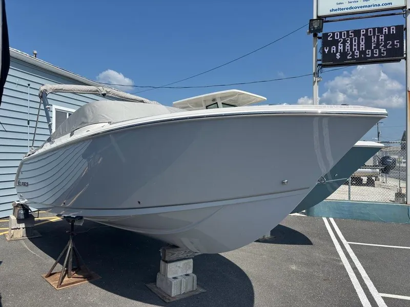 Slide: The Image of 2026 Sailfish 236 DC boat on display at a marina under clear skies. - 1
