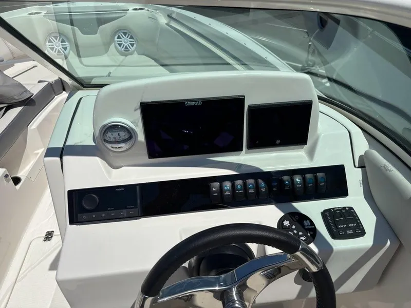 Slide: The Image of 2026 Sailfish 236 DC boat dashboard with steering wheel, controls, and navigation screens. - 10