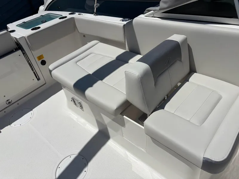 Slide: The Image of 2026 Sailfish 236 DC boat interior with white cushioned seating and storage compartments. - 15