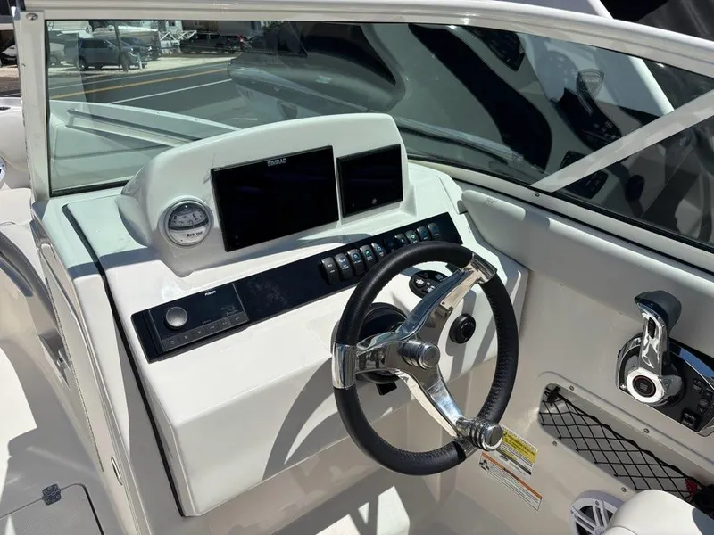 Slide: The Image of 2026 Sailfish 236 DC boat dashboard with steering wheel and control panel. - 9