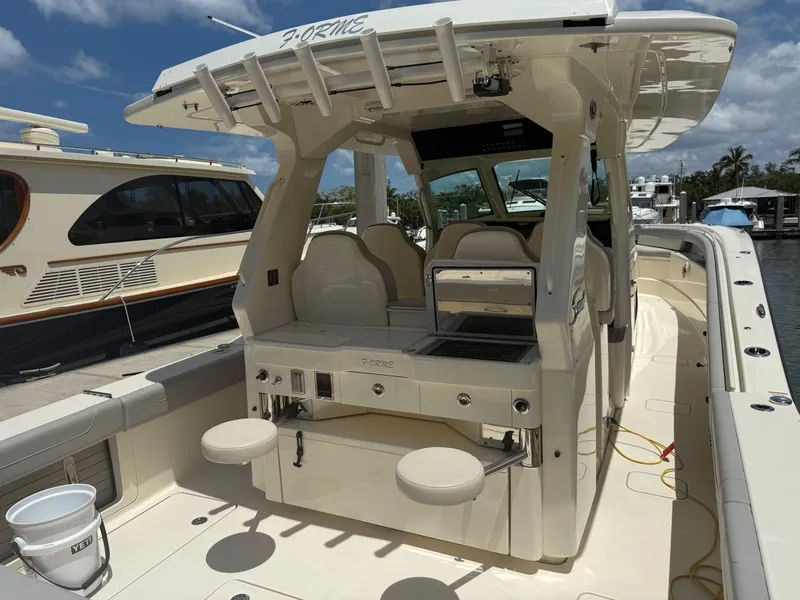 Slide: The Image of 2022 Scout 425 LXF boat with seating and fishing amenities, docked at a marina. - 12