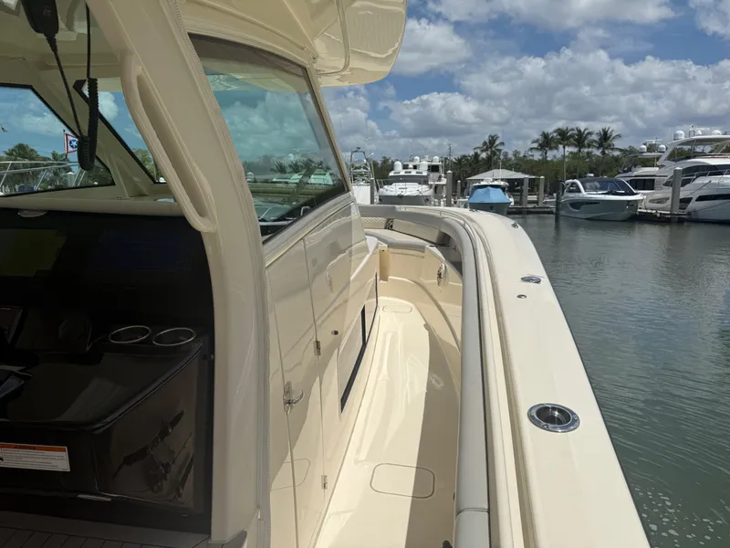 Slide: The Image of 2022 Scout 425 LXF boat docked at marina under blue sky. - 20