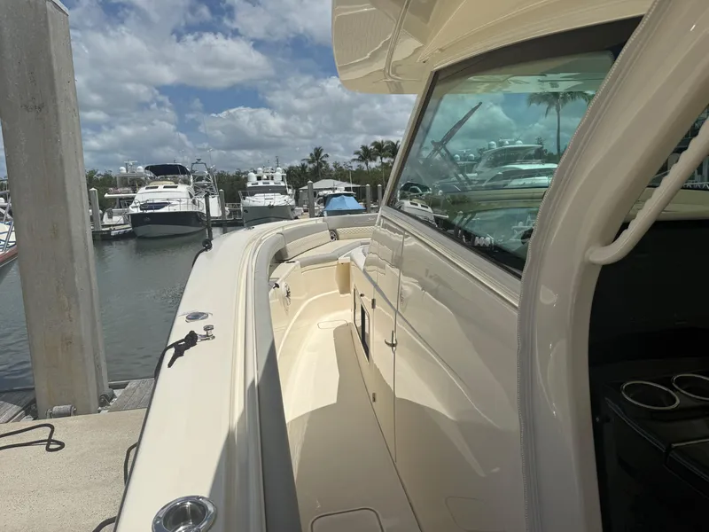 Slide: The Image of 2022 Scout 425 LXF boat docked at marina, showcasing sleek design and spacious deck. - 21