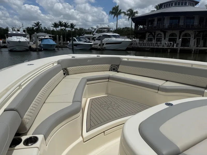Slide: The Image of 2022 Scout 425 LXF boat interior with luxurious seating at a marina. - 23
