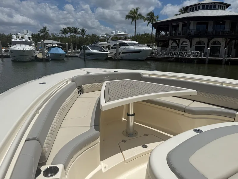 Slide: The Image of 2022 Scout 425 LXF boat with seating area and table, docked at marina. - 25