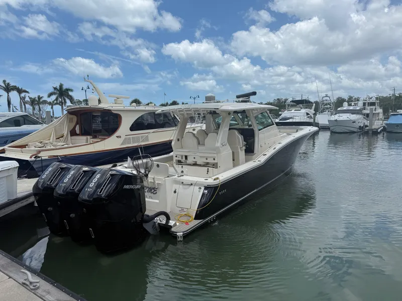 Slide: The Image of 2022 Scout 425 LXF boat docked in marina with multiple outboard engines. - 3