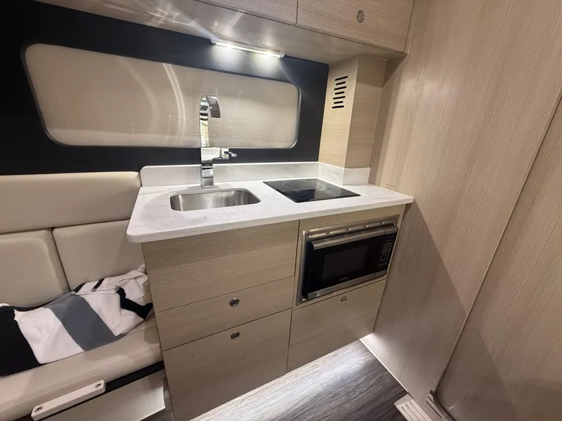 Slide: The Image of 2022 Scout 425 LXF interior kitchen with sink, stove, and microwave. - 32