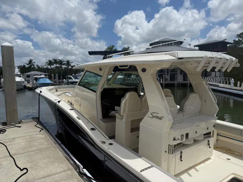 Slide: The Image of 2022 Scout 425 LXF boat docked at marina under cloudy sky. - 5