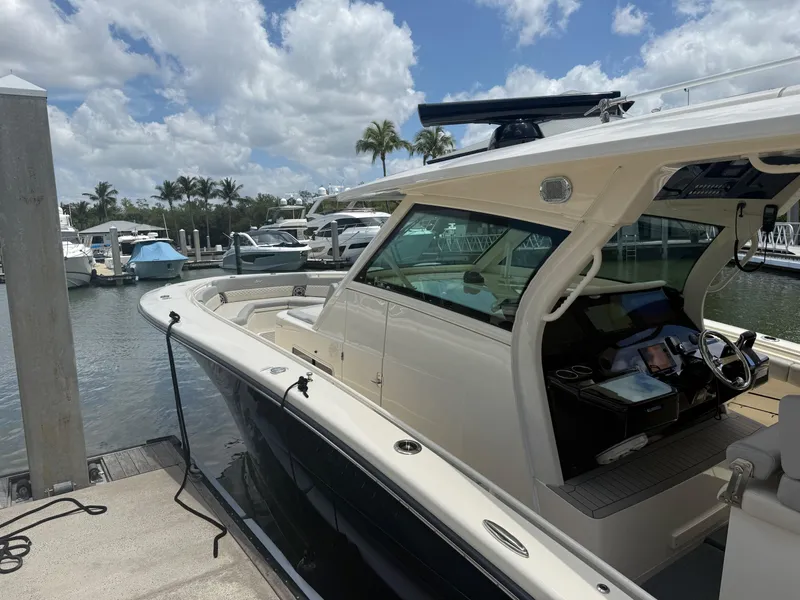 Slide: The Image of 2022 Scout 425 LXF boat docked at marina under blue sky. - 6