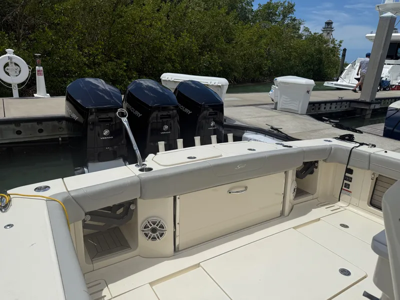 Slide: The Image of 2022 Scout 425 LXF boat with triple outboard engines docked at marina. - 8