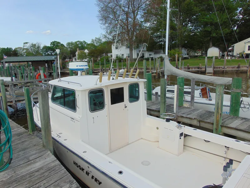 Slide: The Image of 2005 Parker 2520 Deep Vee Sport Cabin boat docked at a marina. - 13