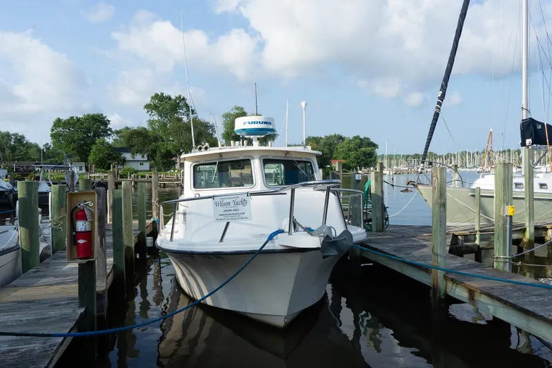 Slide: The Image of 2005 Parker 2520 Deep Vee Sport Cabin boat docked at marina under cloudy sky. - 16
