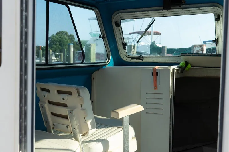 Slide: The Image of Interior of a 2005 Parker 2520 Deep Vee Sport Cabin boat, featuring seating and windows. - 23