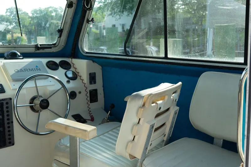 Slide: The Image of Interior of 2005 Parker 2520 Deep Vee Sport Cabin with steering wheel and Garmin equipment. - 24