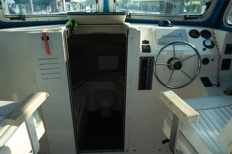 Slide: The Image of 2005 Parker 2520 Deep Vee Sport Cabin interior with steering wheel and Garmin navigation. - 25