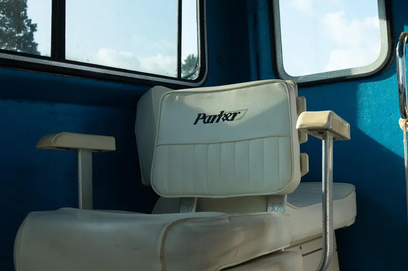 Slide: The Image of White captain's chair inside a 2005 Parker 2520 Deep Vee Sport Cabin boat. - 26