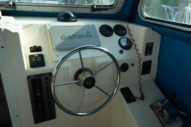 Slide: The Image of Steering wheel and controls of a 2005 Parker 2520 Deep Vee Sport Cabin boat. - 28