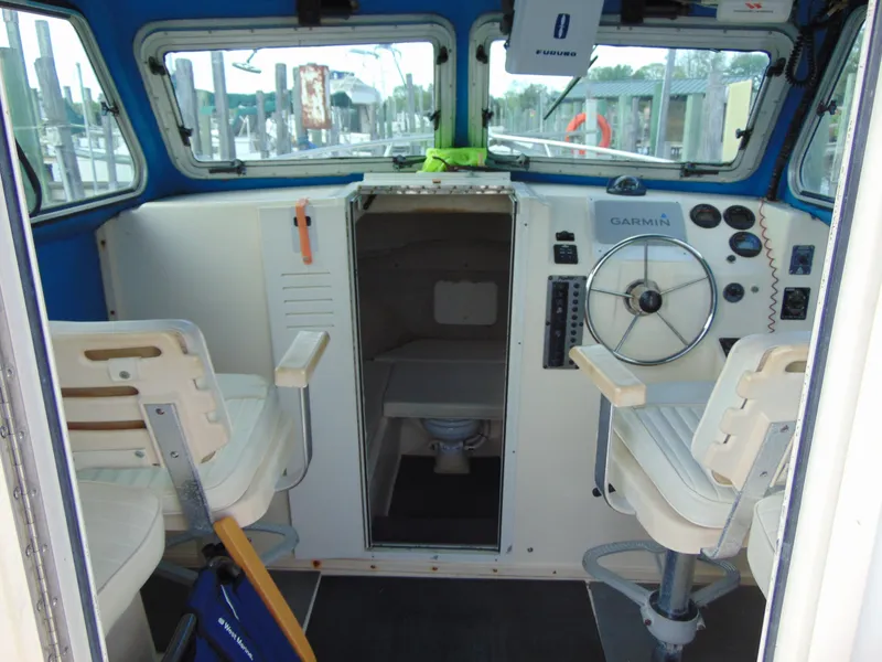 Slide: The Image of 2005 Parker 2520 Deep Vee Sport Cabin interior with steering wheel and seating. - 8