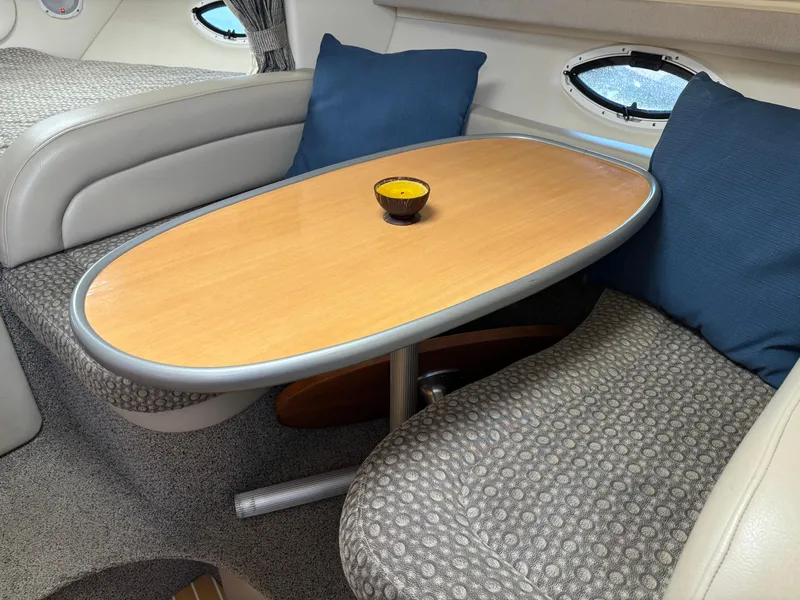Slide: The Image of Interior of 2004 Maxum 2900 SCR boat with cozy seating and wooden table. - 13