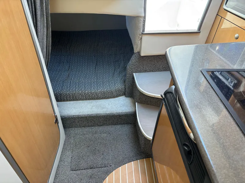 Slide: The Image of Interior of 2004 Maxum 2900 SCR boat, featuring carpeted steps and compact kitchen area. - 16