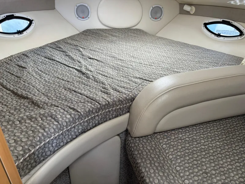 Slide: The Image of 2004 Maxum 2900 SCR cabin interior with patterned bedding and porthole windows. - 17