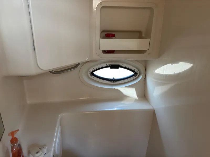Slide: The Image of 2004 Maxum 2900 SCR boat interior with porthole and storage compartments. - 19